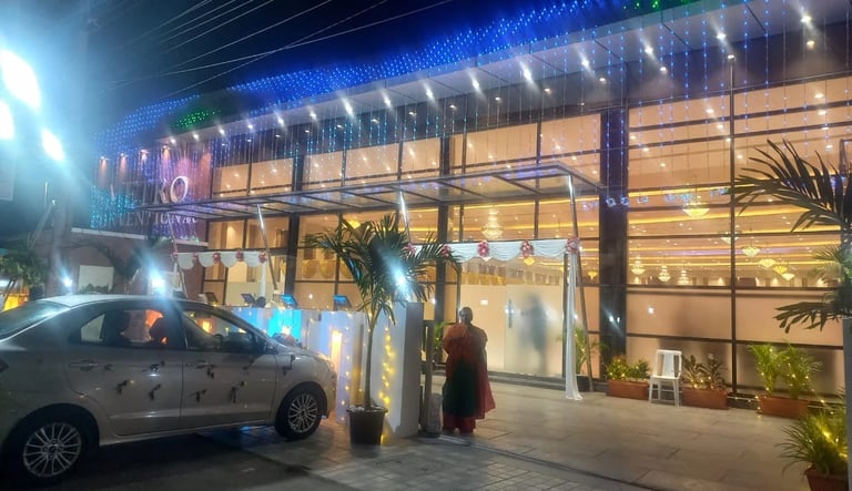 Illuminated luxury wedding convention hall exterior with blue LED lights and floral decorations.