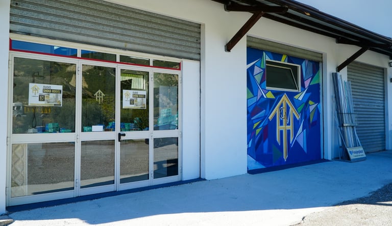 Modern storefront for a window and door showroom featuring glass doors and colorful wall murals.