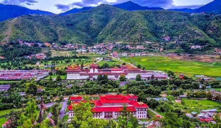 Trashichho-Dzong-Fortress-With-The-Backdrop-View-of-Green-Pristine-Mountain