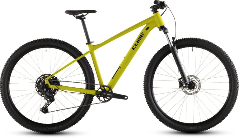 Side profile of a bright yellow Cube hardtail mountain bike with Shimano components and suspension fork.