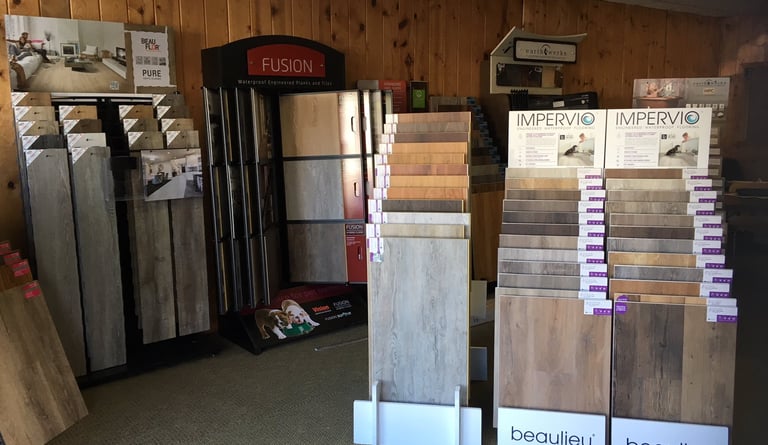 Flooring showroom displaying hardwood, laminate, tile, and vinyl flooring options.