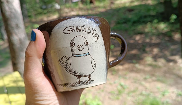 Puodelis su balandžio iliustracija ir užrašu GANGSTA