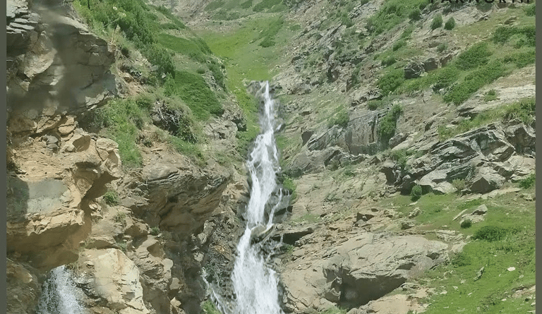 Water stream flowing down by a mountain 