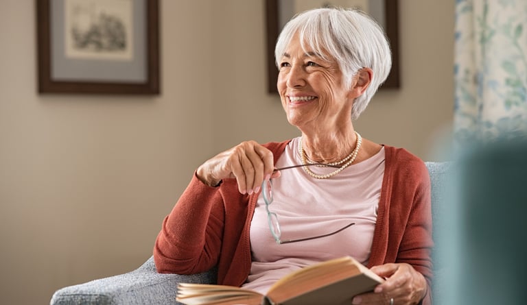 Mujer mayor leyendo un libro con una expresión relajada y feliz. La lectura es una excelente forma d