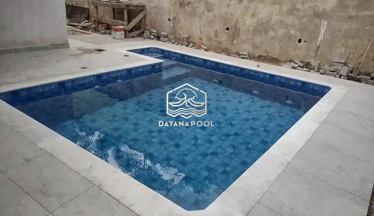 Desain kolam renang dengan sentuhan batu alam, menyoroti tekstur dan warna.