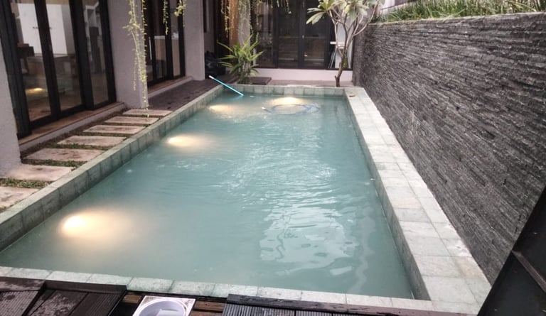 Kolam renang pribadi di malam hari dengan pencahayaan LED yang indah, menciptakan suasana relaksasi.