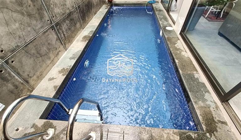 Kolam renang pribadi di malam hari dengan pencahayaan LED yang indah, menciptakan suasana relaksasi.