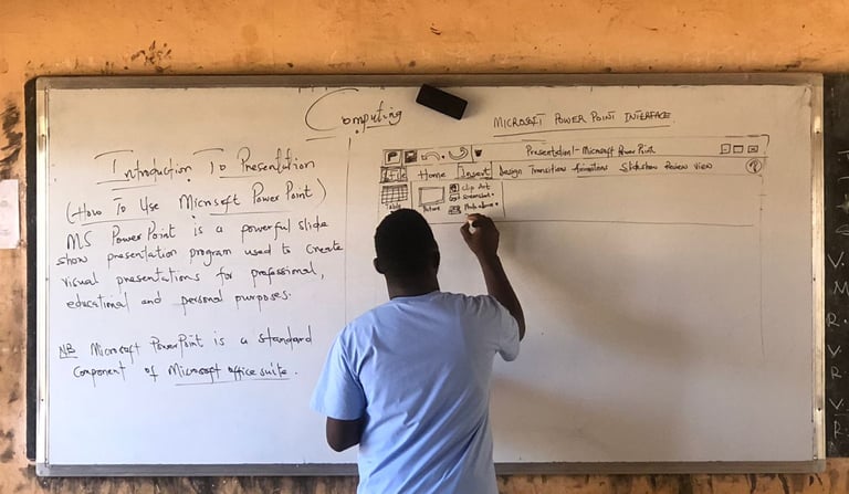 teacher in Ghana teaching computer science on a whiteboard