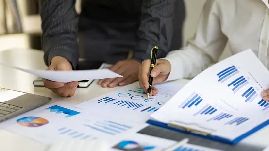 a group of people sitting at a table with papers and papers