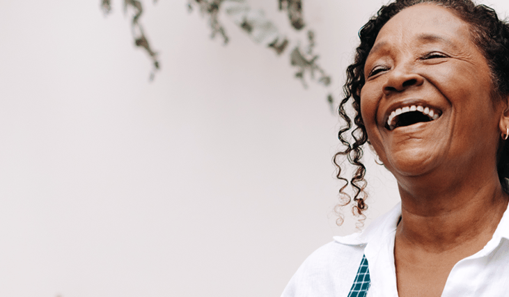 senho sorrindo utilizando aparelhos auditivos