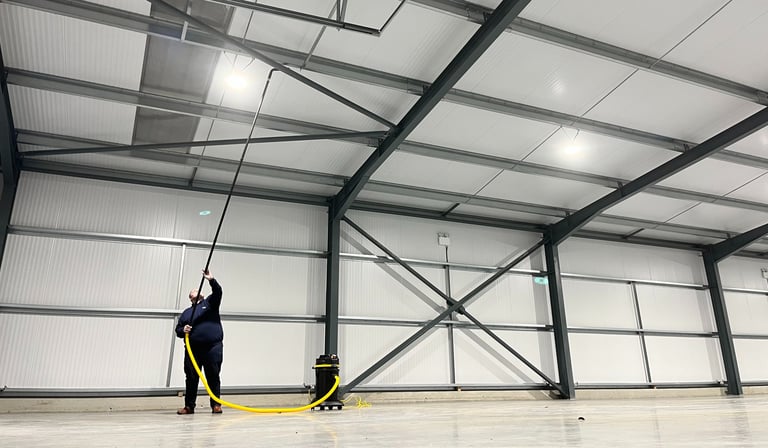 high commercial ceiling being vacuumed