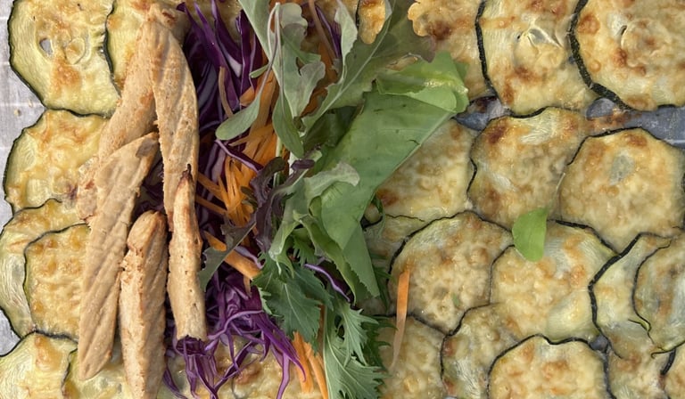 Wrap made of slices of overlapped courgette topped with grilled cheese and Quorn strips and salad