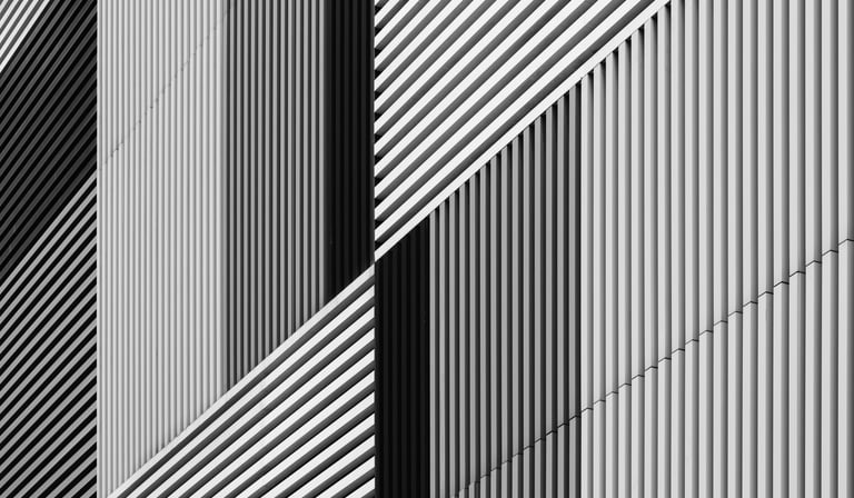 Abstract architectural facade with varying black and white stripes.