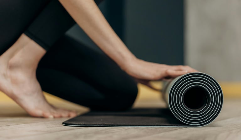 a person rolling up a yoga mat