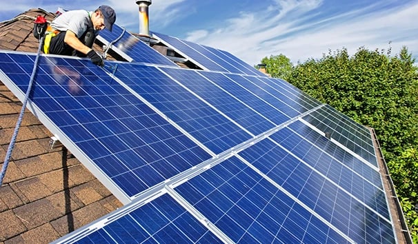 Professional contractor installing solar panels on a residential rooftop for renewable energy.