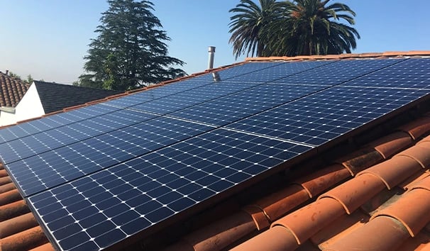 Residential rooftop solar panels on a terra cotta tile roof, generating clean energy for a home, improving energy efficiency.