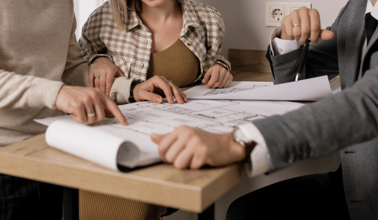 Clientes olhando o projeto da reforma do apartamento com o corretor.