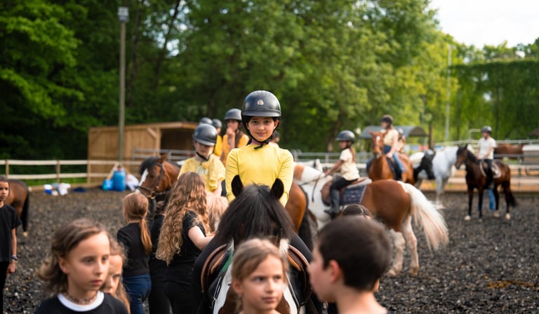 a group of kids riding on horses in a pen