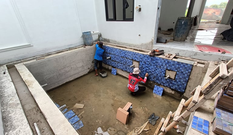 proses pembuatan kolam renang dan pemasangan keramik roman motif mozaik.