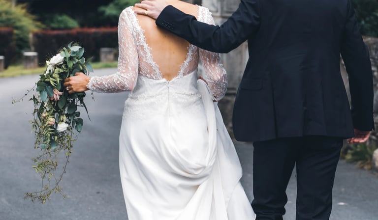 Couple de jeunes mariés de dos qui marchent ensemble