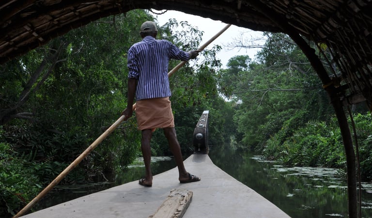 Man punting a boat in boat in Kochi, Kerala, India