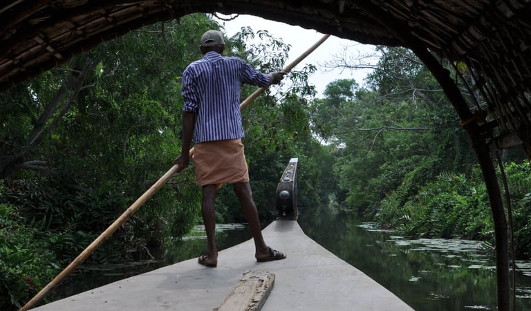 Man punting a boat in boat in Kochi, Kerala, India