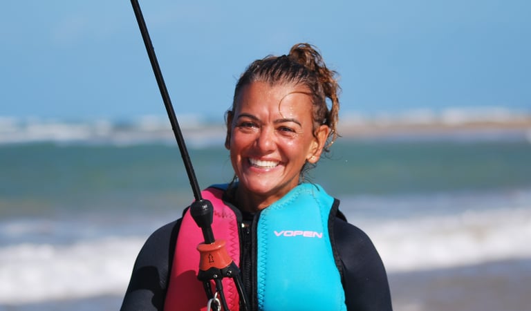 a woman in a wetsuit connecte a kitesurf