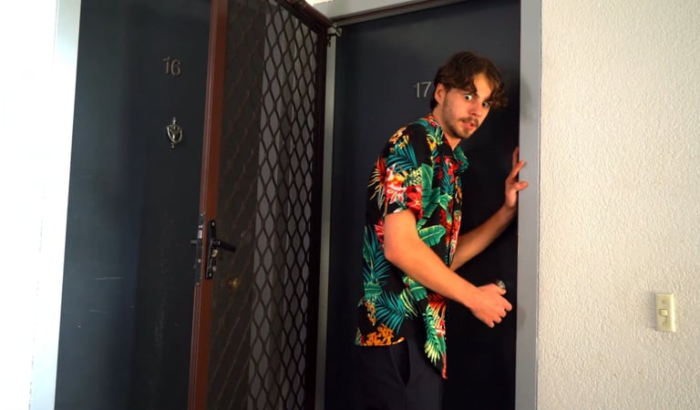 a man in a hawaiian shirt is standing in a doorway