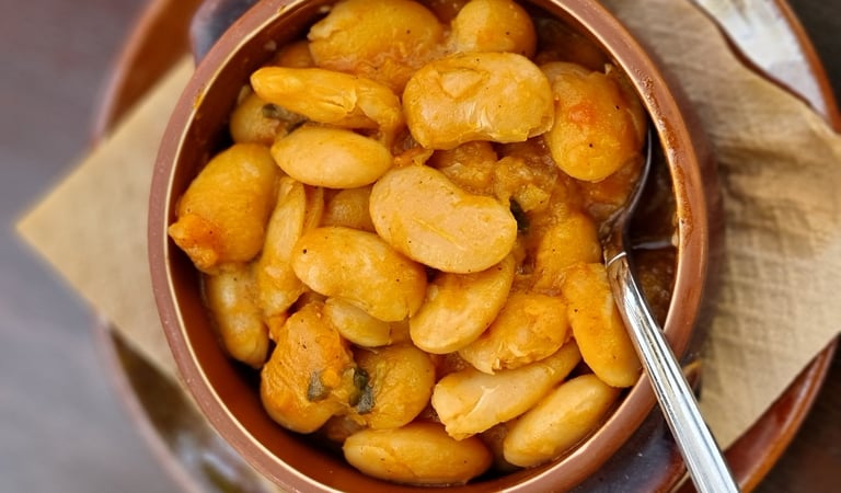 A bowl of Greek Gigantes Plaki, large butter beans baked in a savory tomato sauce.