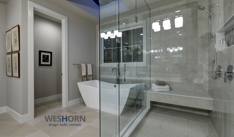 Modern bathroom remodel featuring a glass walk-in shower and freestanding soaking tub.