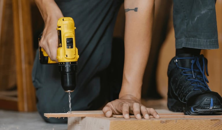 Carpenter drilling holes in wood with a drill machine