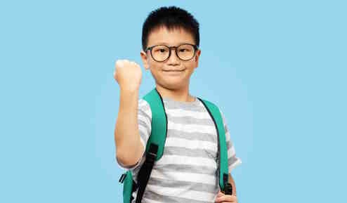 boy with school backpack wearing glasses giving fist pump