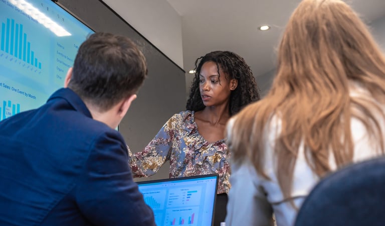 Woman presenting data on a screen to colleagues during a meeting.