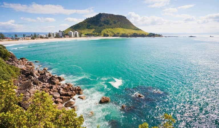 Vista do monte e do mar da Bay of Plenty em Tauranga, com a cidade ao fundo e céu claro.