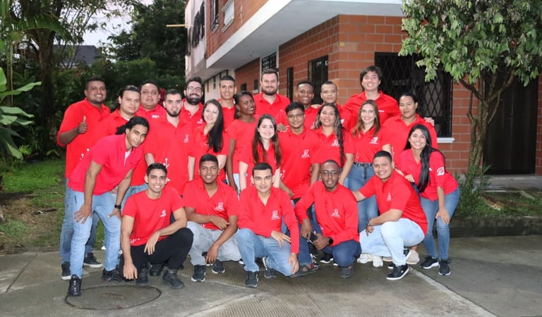 a group of people in red shirts and jeans posing for a group photo