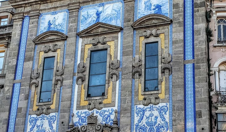 Blue and white mosaic-covered exterior of Igreja Church with three arched windows in Porto, Portugal