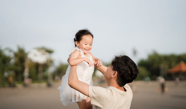 Father lifting his daughter during a joyful family photography session at Petitenget Beach Seminyak Bali