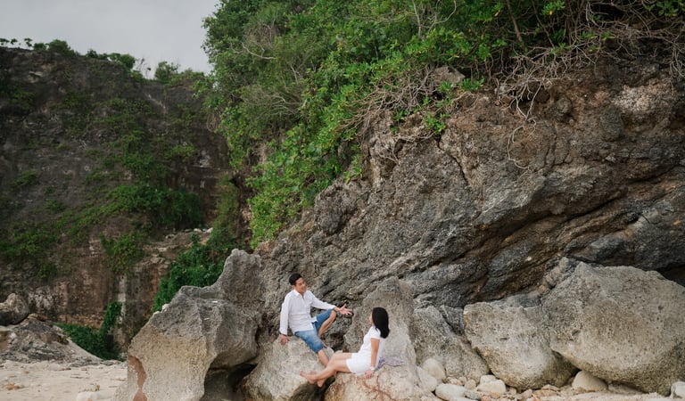 Family sitting near the limestone cliffs of Melasti Beach Bali captured during a lifestyle family photography session
