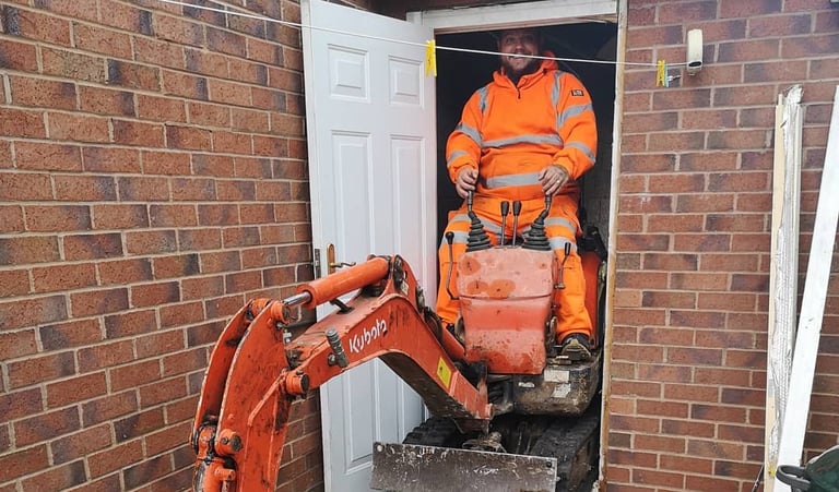 Digger operator preparing foundation for new build in Dudley