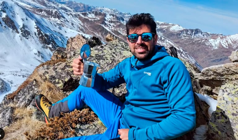 guía de montaña con una cafetera en la cima