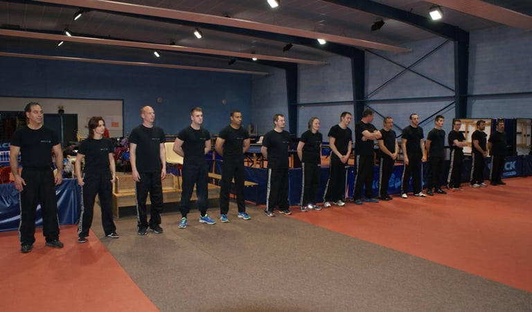 a group of people standing in line with their hands on their hips krav maga