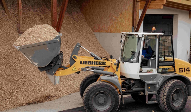 ein radlader mit einer schaufel voll mit Hackschnitzel hackgut biomasse