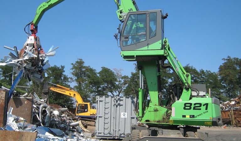 Une grue soulève de la ferrailles 