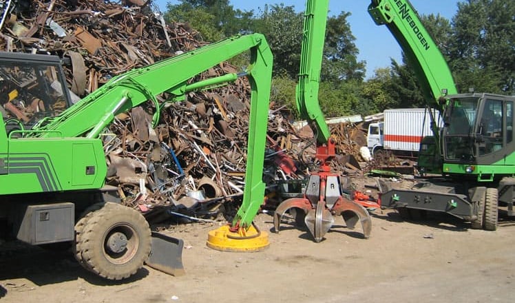 Une excavatrice verte avec une grue dessus