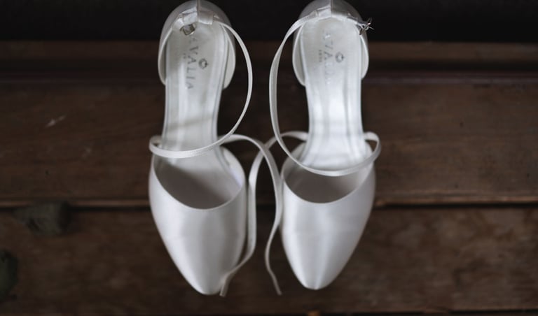a bride's pair of white wedding shoes