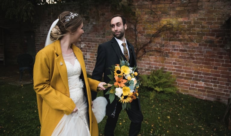 a bride and groom walking together holding hands