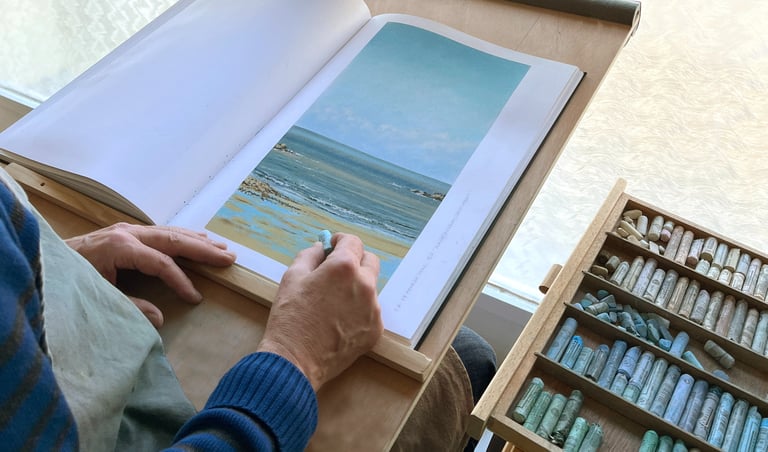 Photographie d'artiste en action pour faire un paysage au pastel sec. 