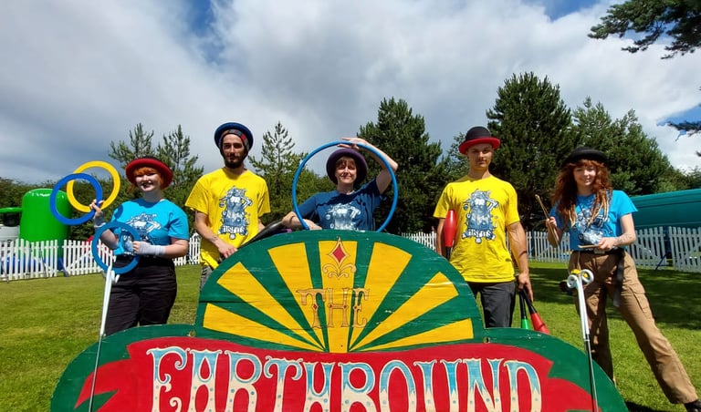 The Earthbound Misfits workshop team performing outdoor juggling and hula hoop skills.