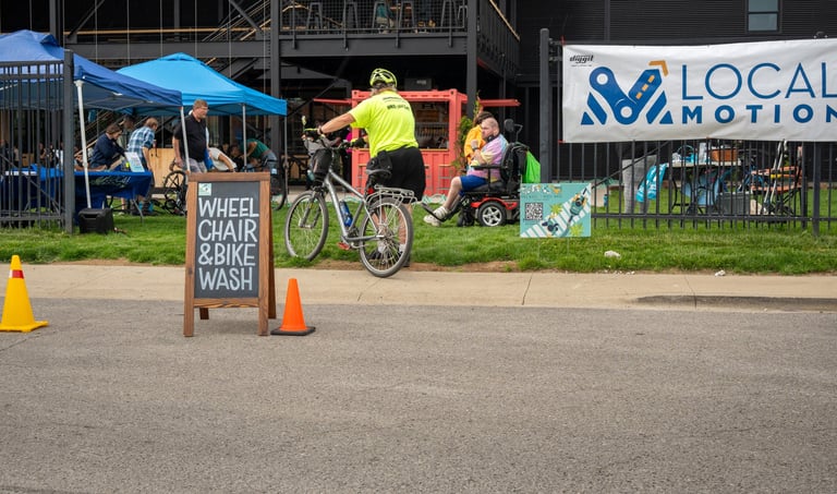 Photo of the event in the Logboat green area with the "Wheelchair & Bike Wash" sign in the road