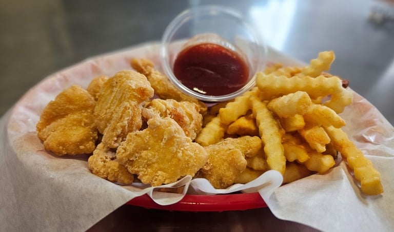 Crispy fried chicken bites and crinkle cut fries with BBQ dipping sauce at Captain's Galley